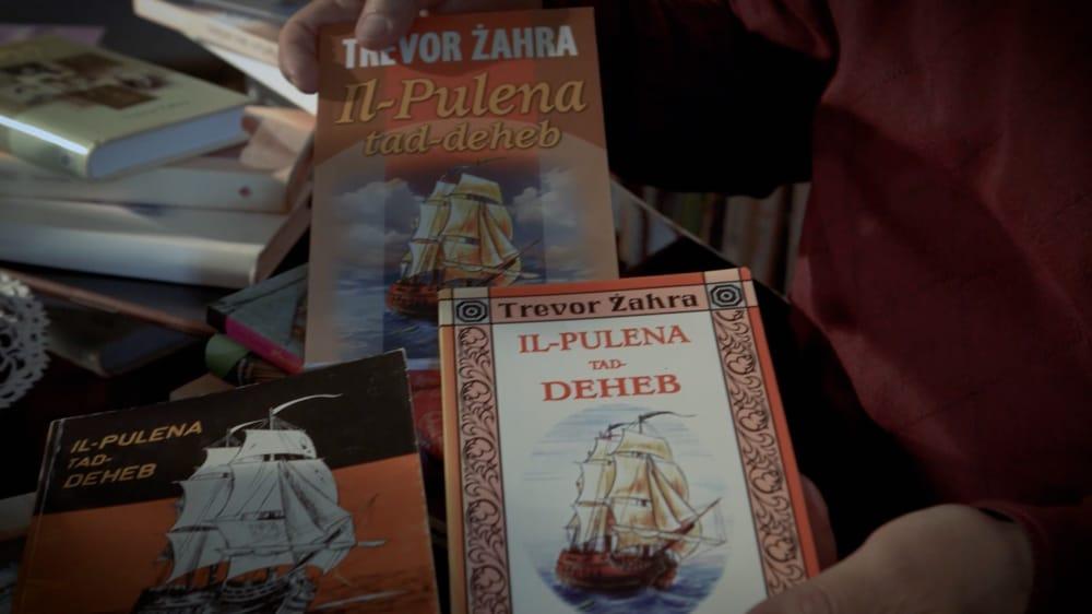 Trevor Zahra showing three different print editions of his Il-Pulena tad-Deheb