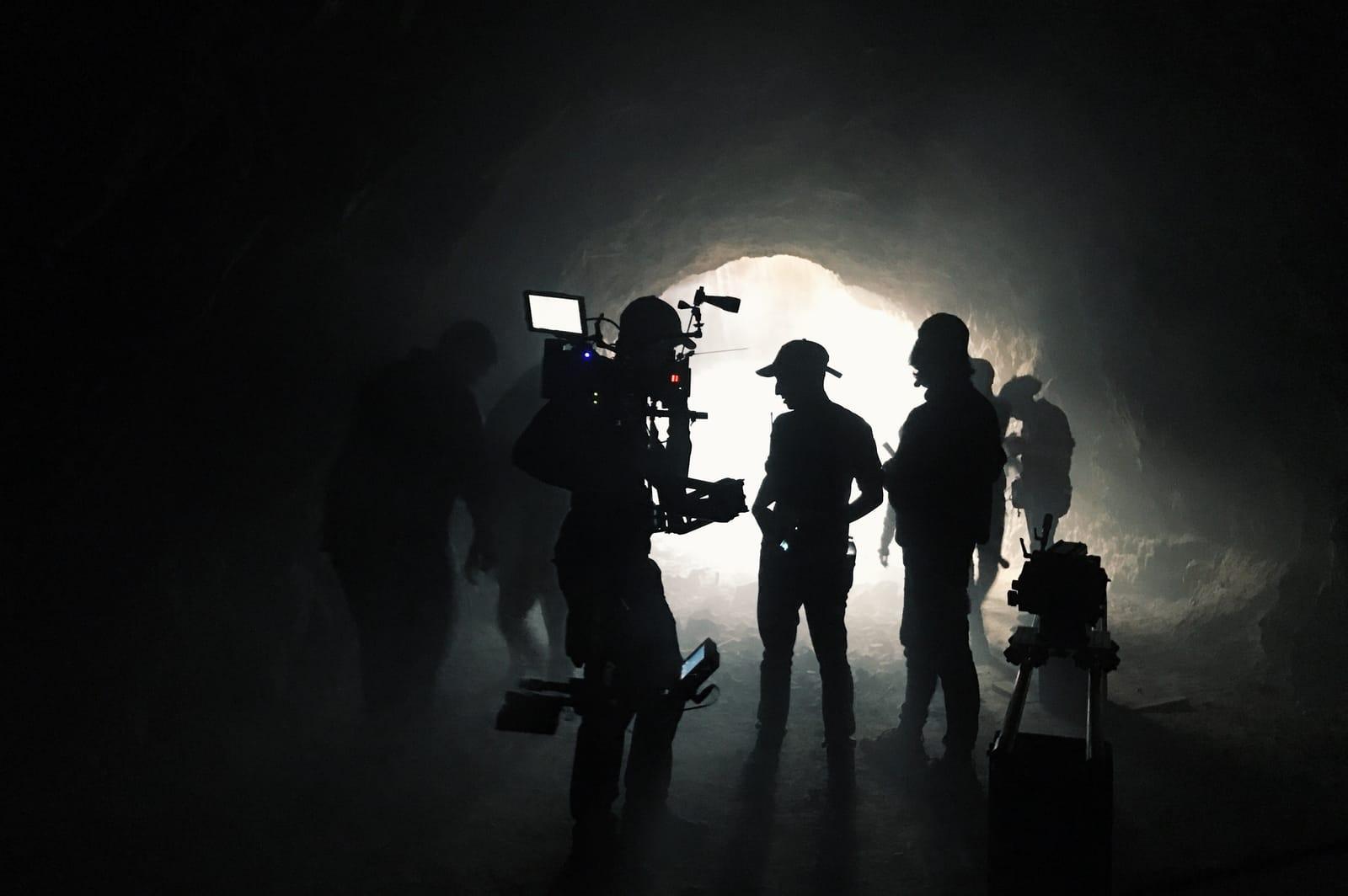 film crew in a dark tunnel